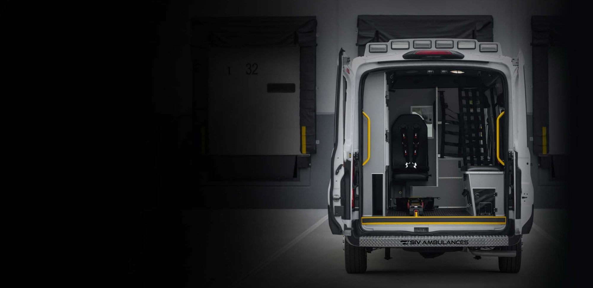 Rear doors open on an SIV ambulance showing the patient compartment, attendant seat and grab rails